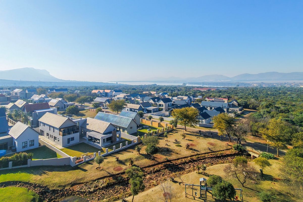 An aerial view of a residential estate featuring established homes, landscaped grounds, and surrounding natural landscape.