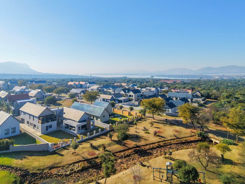 An aerial view of a residential estate featuring established homes, landscaped grounds, and surrounding natural landscape.
