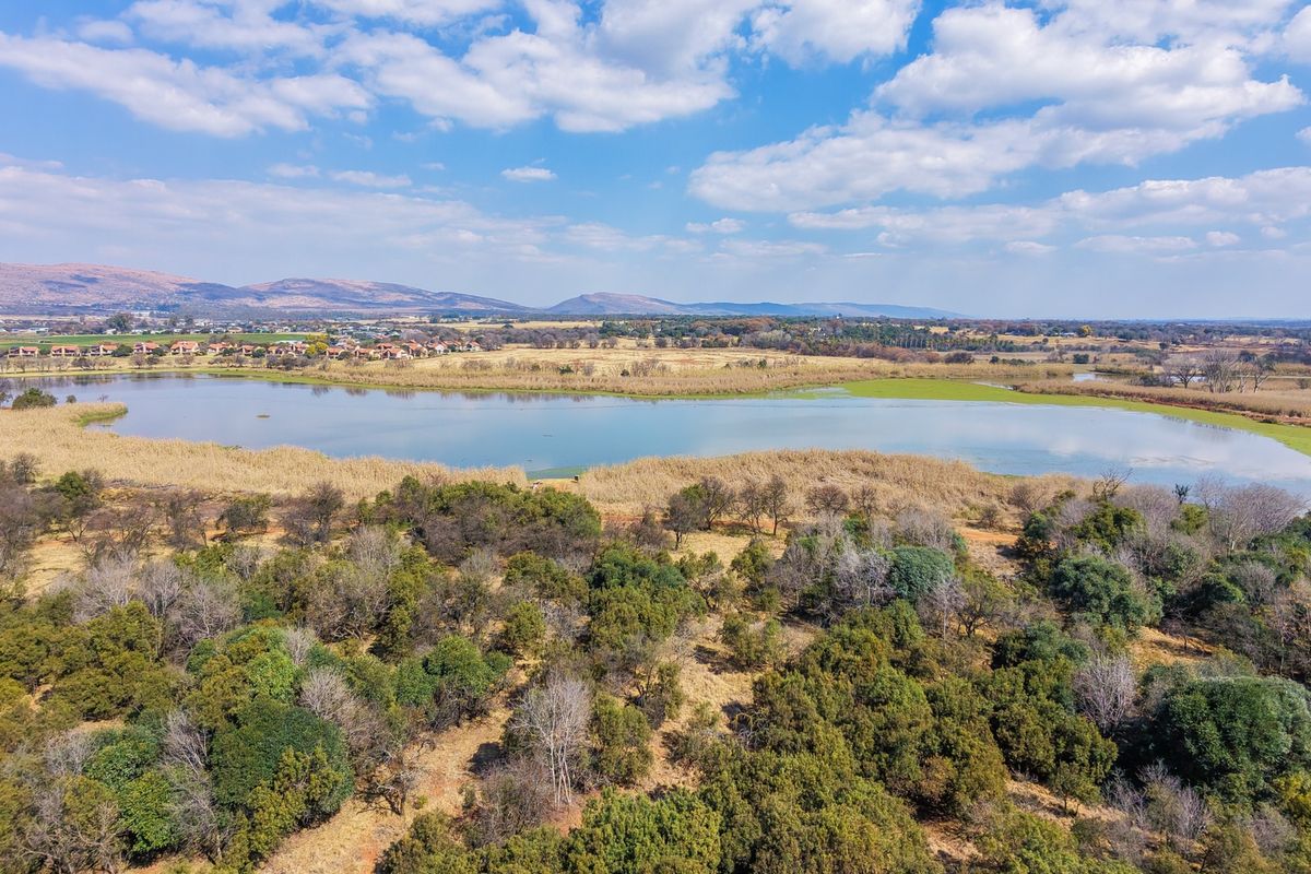 An aerial view of the vacant residential land featuring natural vegetation and scenic lake views.