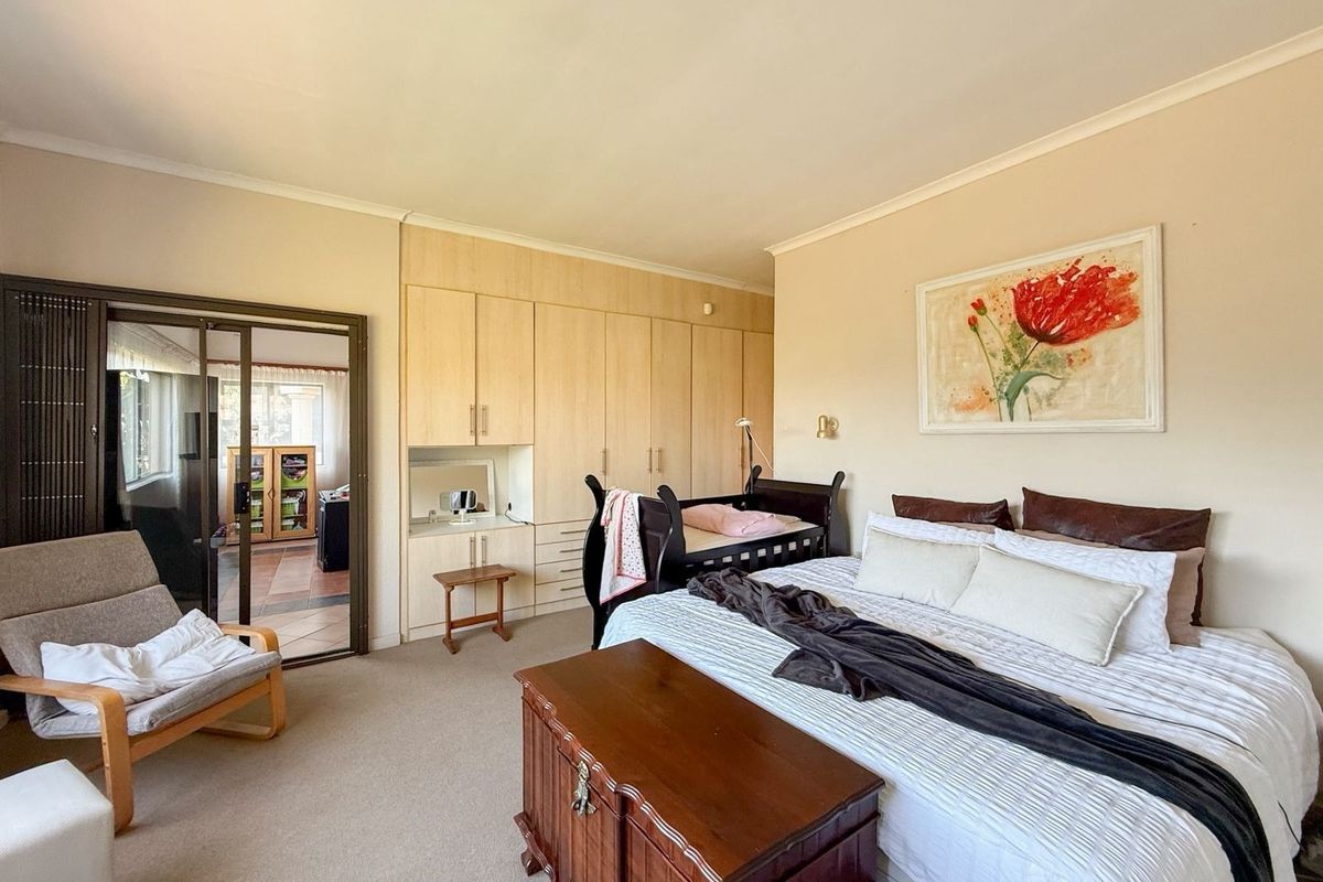 Spacious bedroom featuring neutral walls, carpeted flooring, and extensive built-in cabinetry with an integrated vanity area.