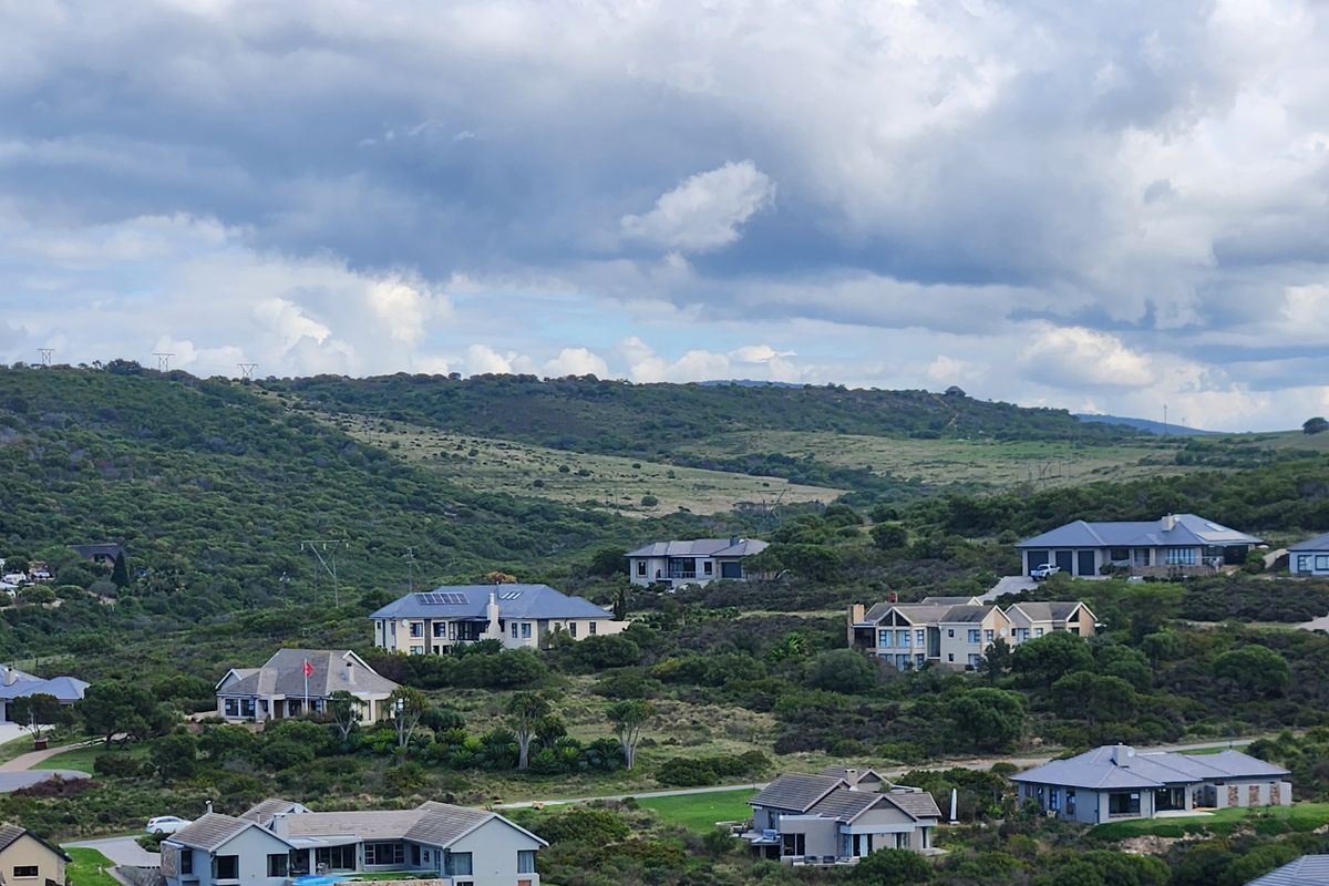 An elevated aerial view of a residential estate featuring multiple detached houses nestled within a natural, landscaped hillside environment.