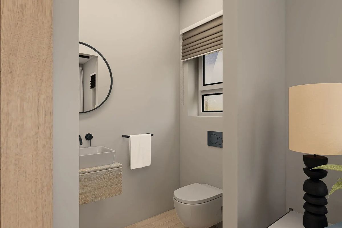 A modern, compact guest bathroom featuring a wall-mounted vanity with a vessel sink, a wall-hung toilet, and a sleek black faucet.