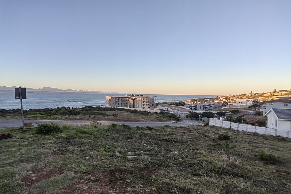 A scenic elevated view overlooking the coastline, nearby residential developments, and the ocean horizon.