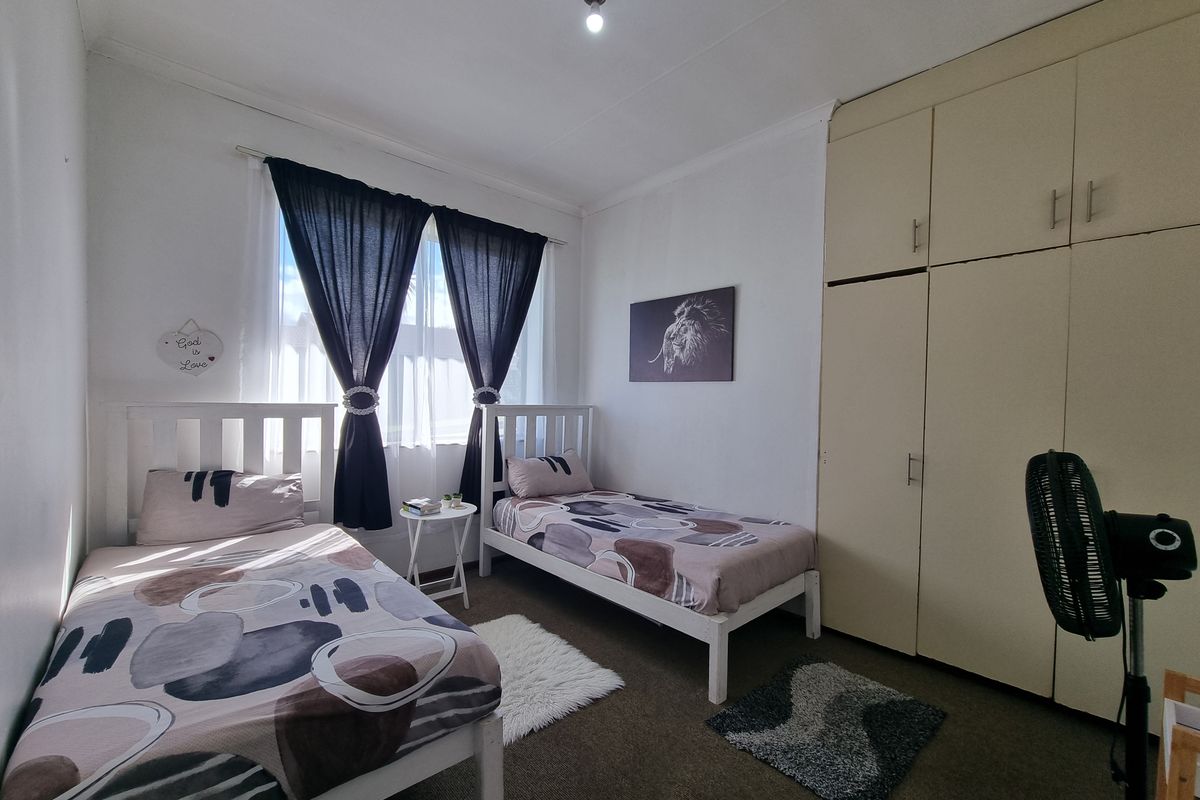 A functional bedroom featuring built-in cupboards and carpeted flooring, providing ample storage and a comfortable living space.
