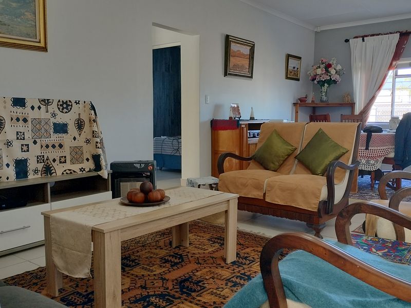 A comfortable living room featuring tiled flooring and coved ceilings, providing a functional and well-lit space for relaxation.