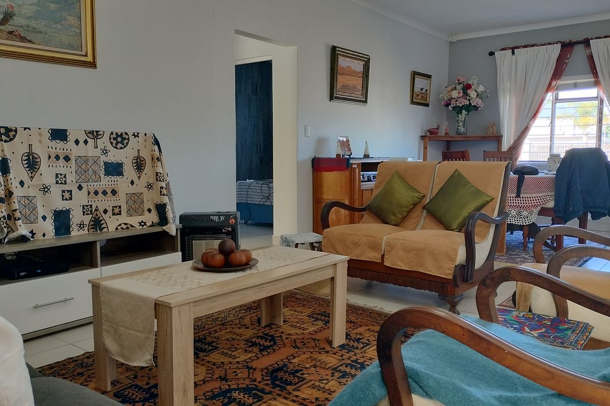 A comfortable living room featuring tiled flooring and coved ceilings, providing a functional and well-lit space for relaxation.