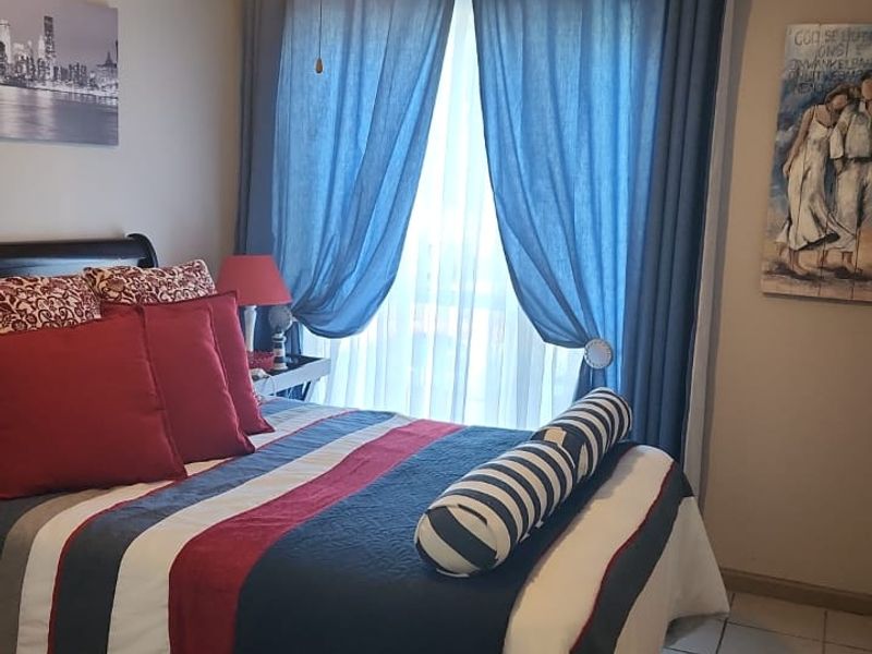 A cozy bedroom featuring tiled flooring and a central ceiling fan, providing a comfortable and functional living space.