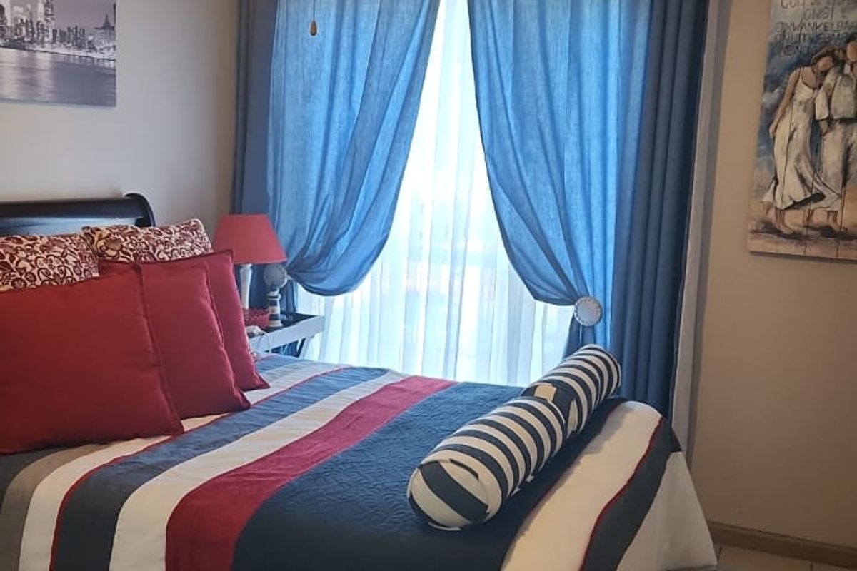 A cozy bedroom featuring tiled flooring and a central ceiling fan, providing a comfortable and functional living space.