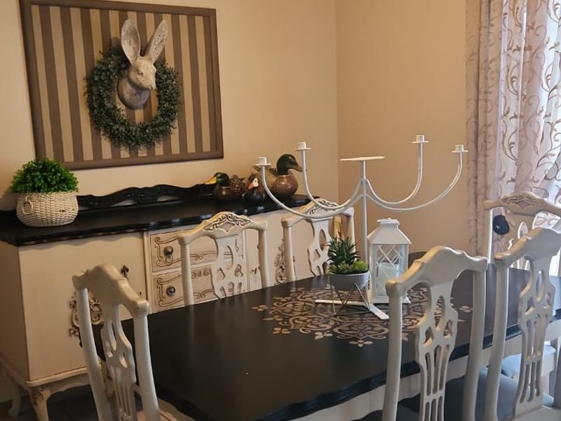 A dining room featuring tiled flooring and a ceiling-mounted spotlight fixture, providing a functional space for meals.