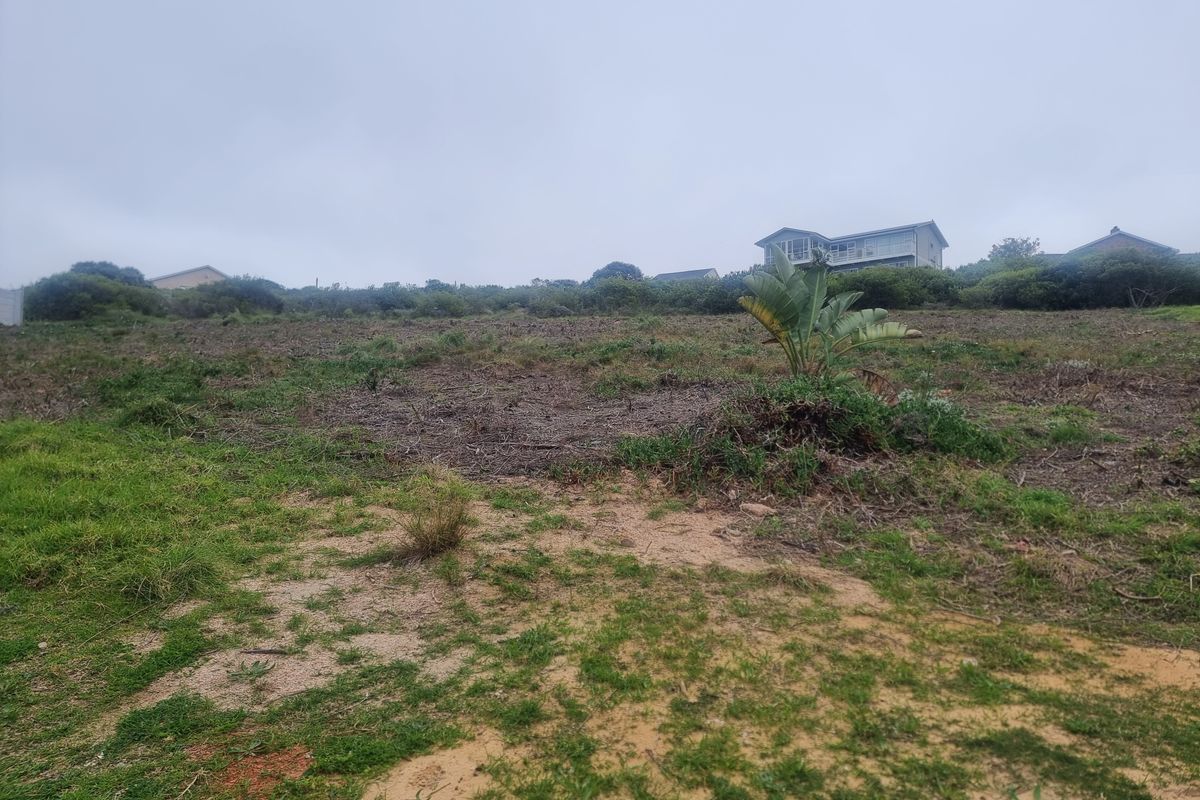 A view of a vacant residential plot featuring sloped terrain and natural vegetation, suitable for future development.