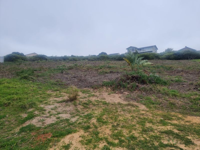 A view of a vacant residential plot featuring sloped terrain and natural vegetation, suitable for future development.