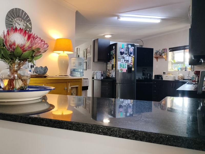 A functional kitchen featuring dark cabinetry and a polished granite breakfast bar, providing a practical workspace for daily meal preparation.