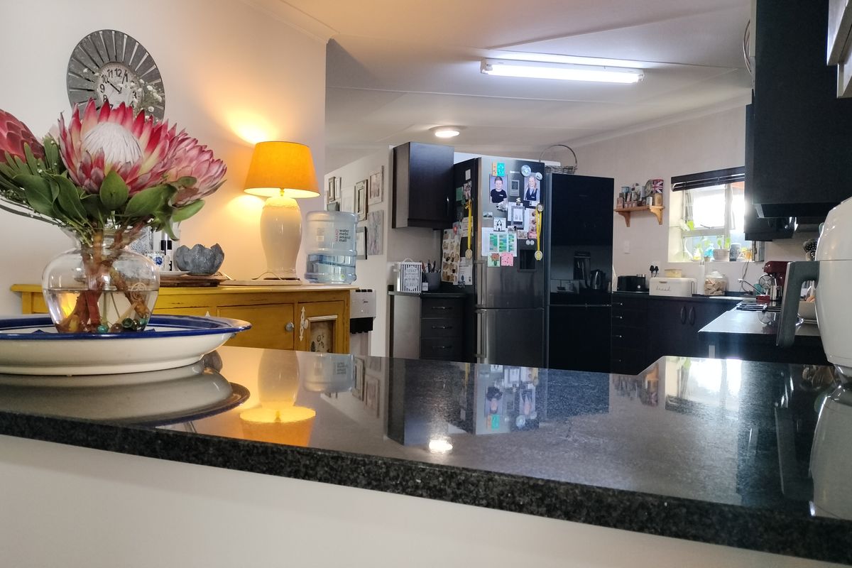 A functional kitchen featuring dark cabinetry and a polished granite breakfast bar, providing a practical workspace for daily meal preparation.