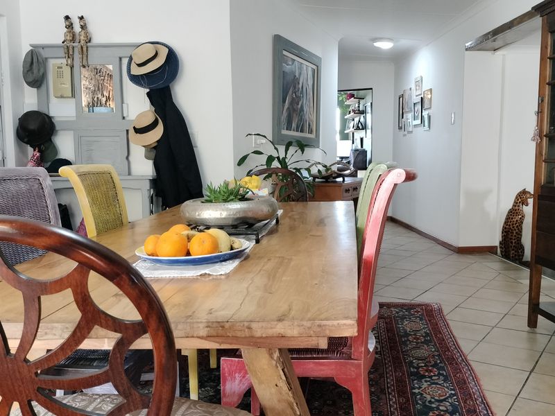 A dining area featuring ceramic floor tiles and coved ceilings, providing a functional space that connects to the hallway and adjacent living areas.