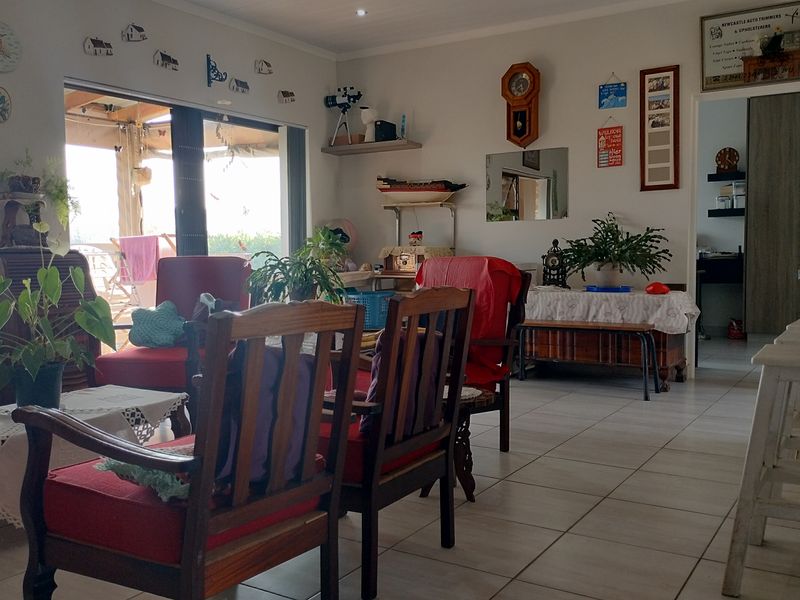 A spacious living area featuring neutral tiled flooring and a large sliding glass door that provides access to the outdoor patio area.