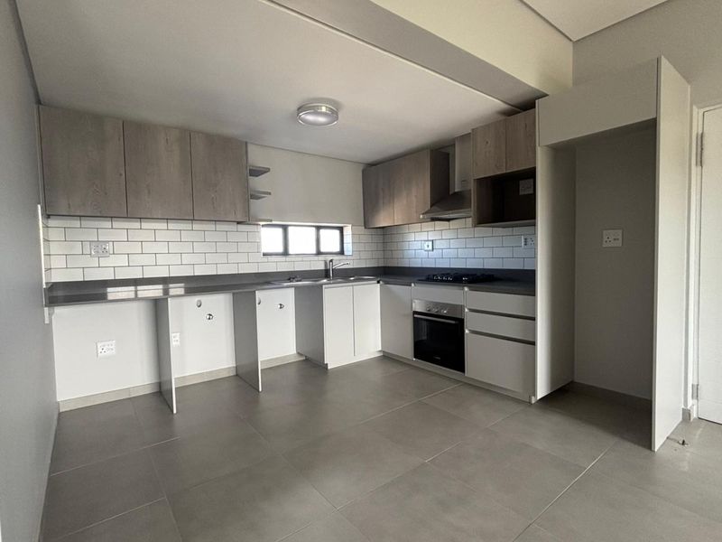 Modern kitchen featuring neutral cabinetry, subway tile backsplash, built-in oven, gas hob, and extractor fan, with ample space for appliances.