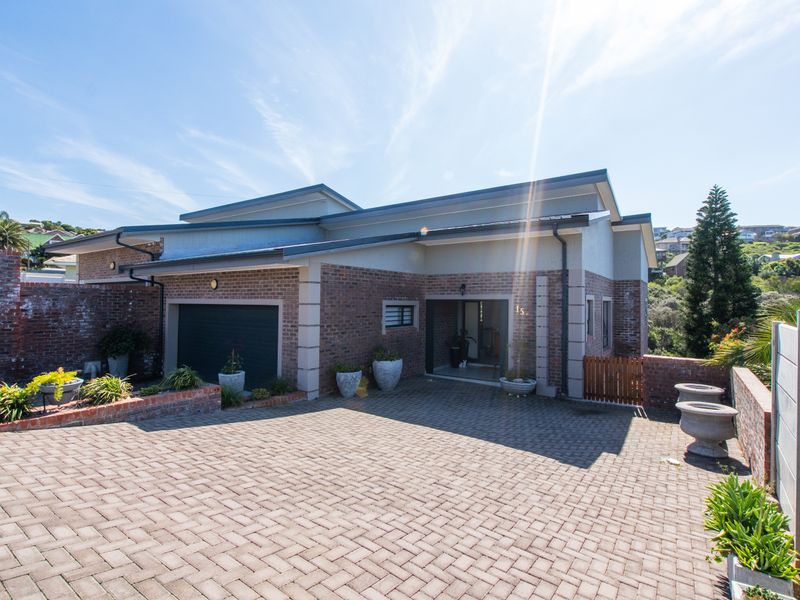 Front elevation of a duet property featuring a paved driveway, brick facade, and integrated single garage.