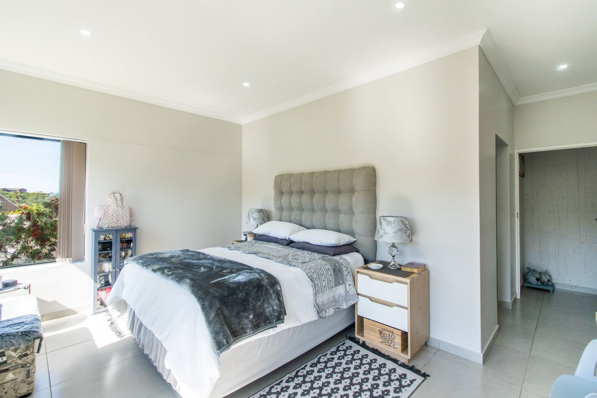A well-maintained bedroom featuring neutral walls, tiled flooring, recessed downlighting, and modern cornicing, offering a clean and bright living space.