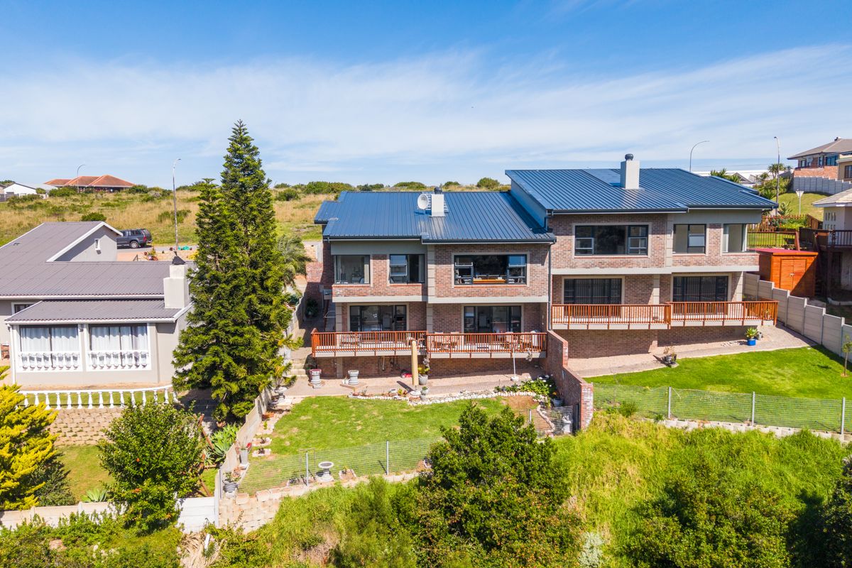 Aerial view of a multi-story brick duet property featuring a modern metal roof, wooden balconies, and a private rear garden area.