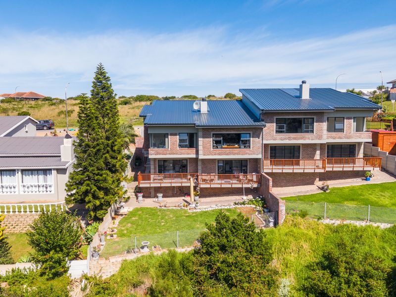 Aerial view of a multi-story brick duet property featuring a modern metal roof, wooden balconies, and a private rear garden area.