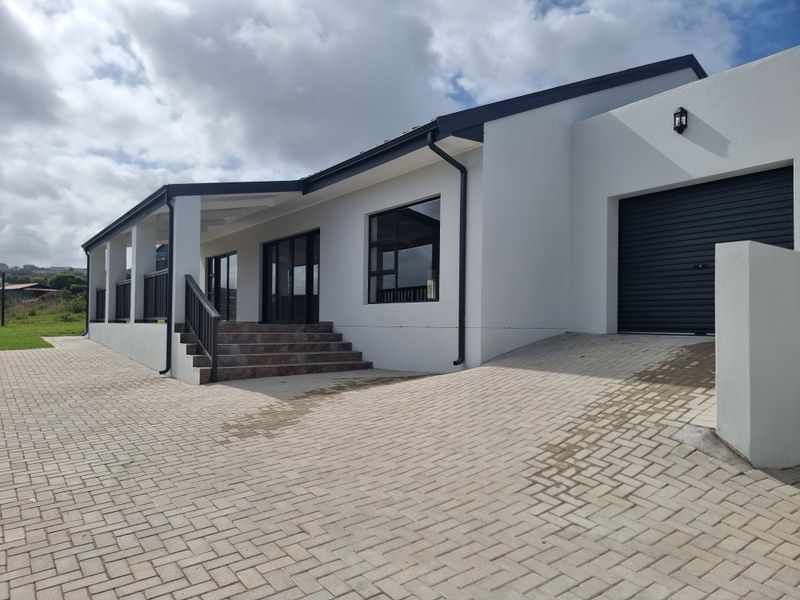 Modern duet property exterior featuring a paved driveway, single garage, and a covered patio area with tiled steps.