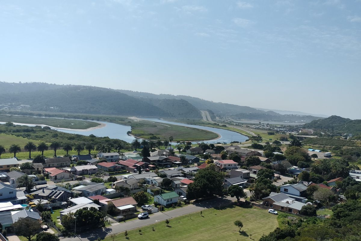 An elevated aerial view of a residential neighborhood situated near a river and coastal landscape.