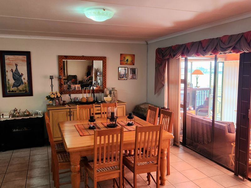 A dining room featuring tiled flooring and large sliding glass doors that provide access to an adjoining patio area.