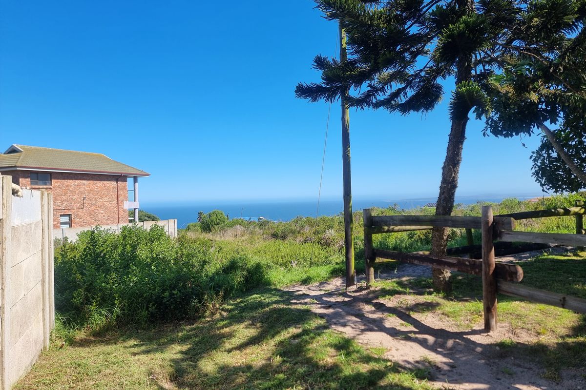 A scenic view of the coastline from the property, featuring natural vegetation and rustic timber fencing.