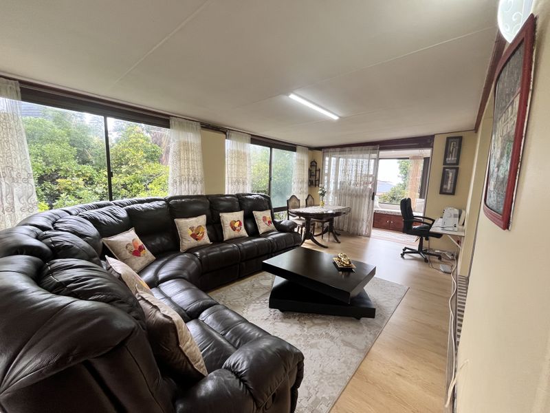 Spacious living area featuring large sliding glass doors that provide ample natural light and views of the surrounding greenery.