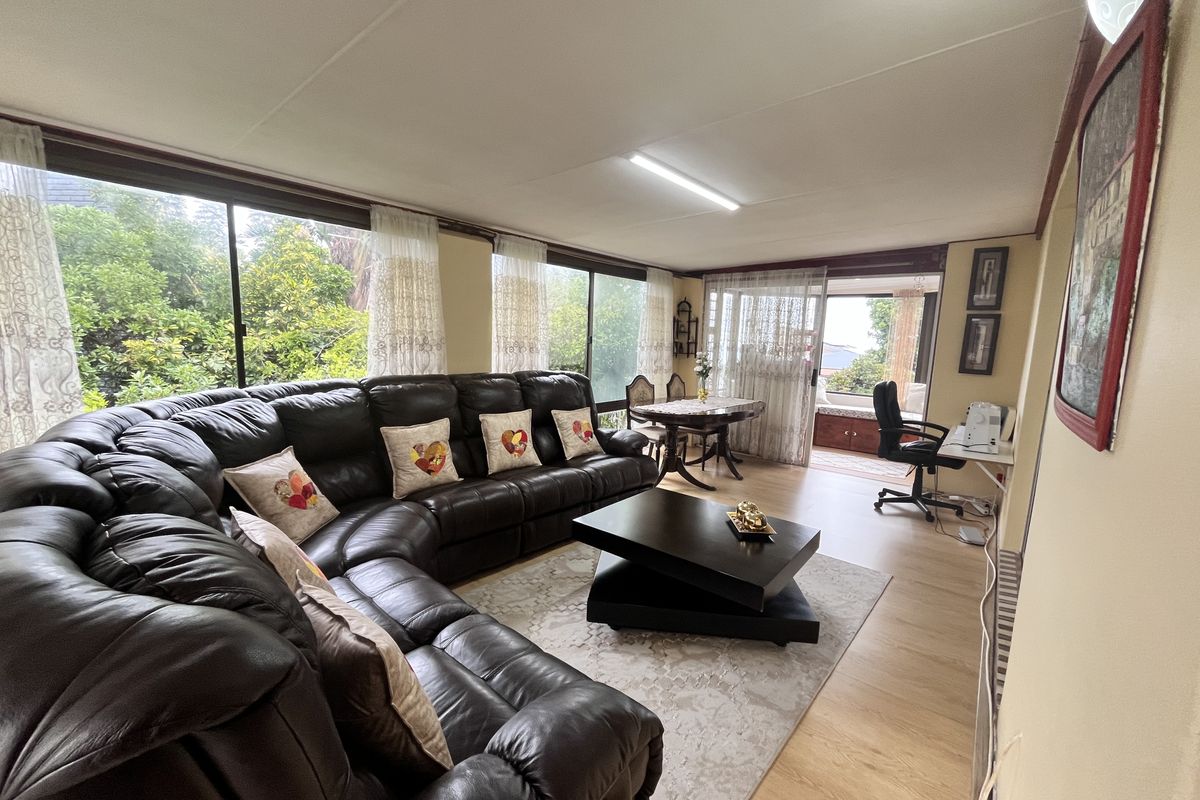 Spacious living area featuring large sliding glass doors that provide ample natural light and views of the surrounding greenery.