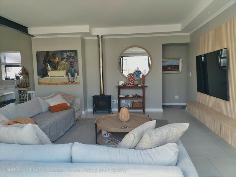 Modern living room featuring a sleek freestanding fireplace, recessed ceiling detail, and a contemporary slatted timber feature wall with integrated media console.