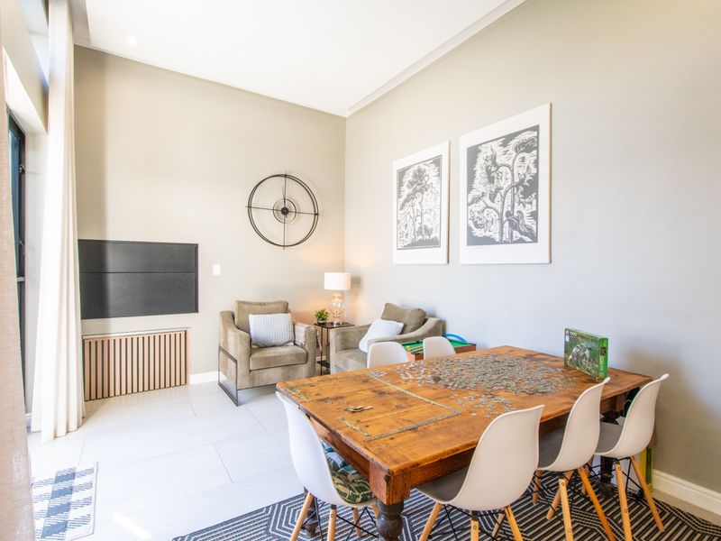 A bright and spacious living area featuring neutral wall tones, tiled flooring, and recessed ceiling lighting, creating a comfortable and inviting atmosphere.