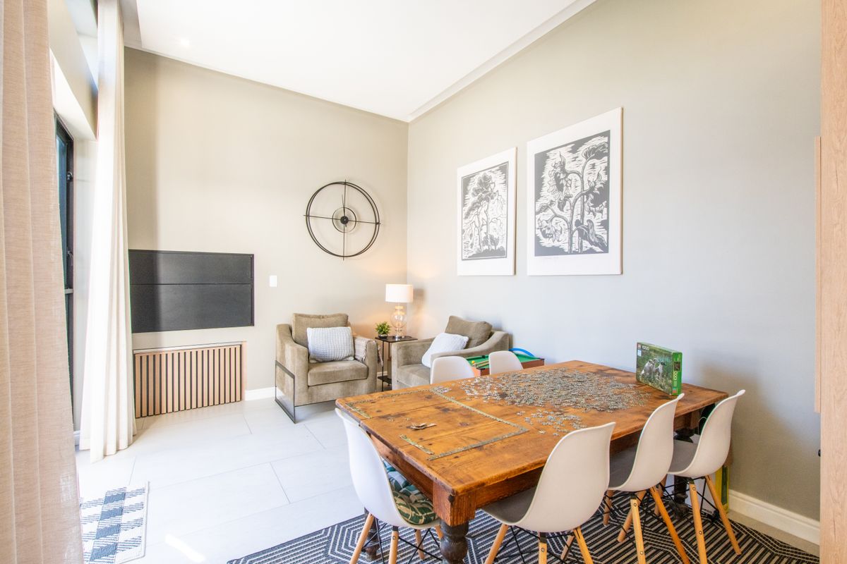 A bright and spacious living area featuring neutral wall tones, tiled flooring, and recessed ceiling lighting, creating a comfortable and inviting atmosphere.