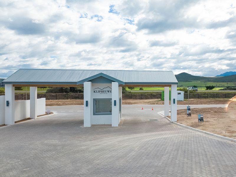 A modern security gatehouse entrance for Klipheuwe Estate, featuring a paved driveway and clean architectural lines.