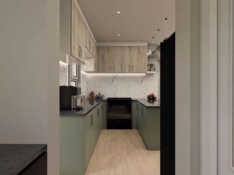 A modern, well-appointed kitchen featuring sage green lower cabinetry, wood-tone upper cabinets, stone countertops, and a marble-look backsplash with integrated oven.