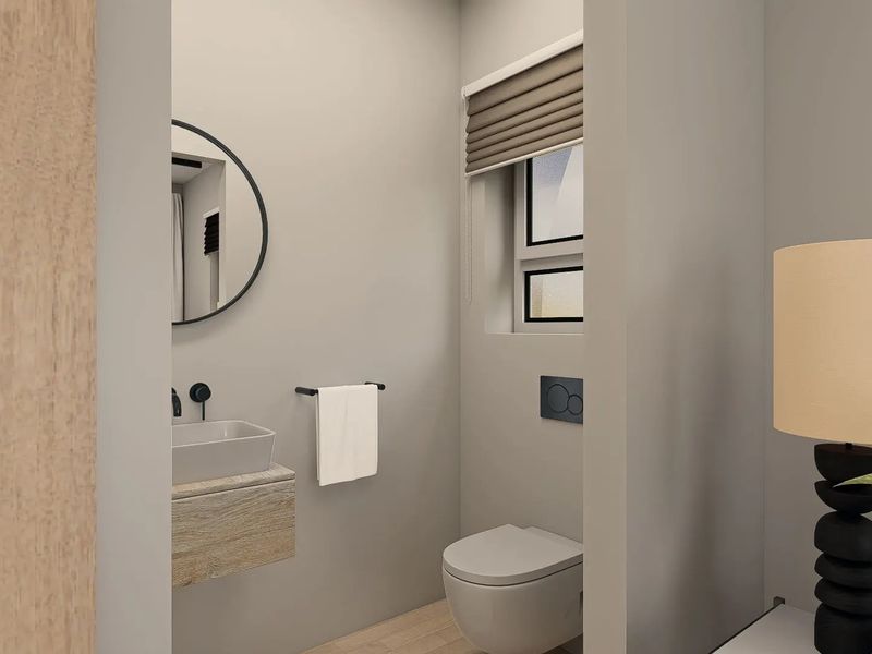 A modern, minimalist guest bathroom featuring a wall-mounted vanity with a vessel sink, a wall-hung toilet with a concealed cistern, and neutral finishes.