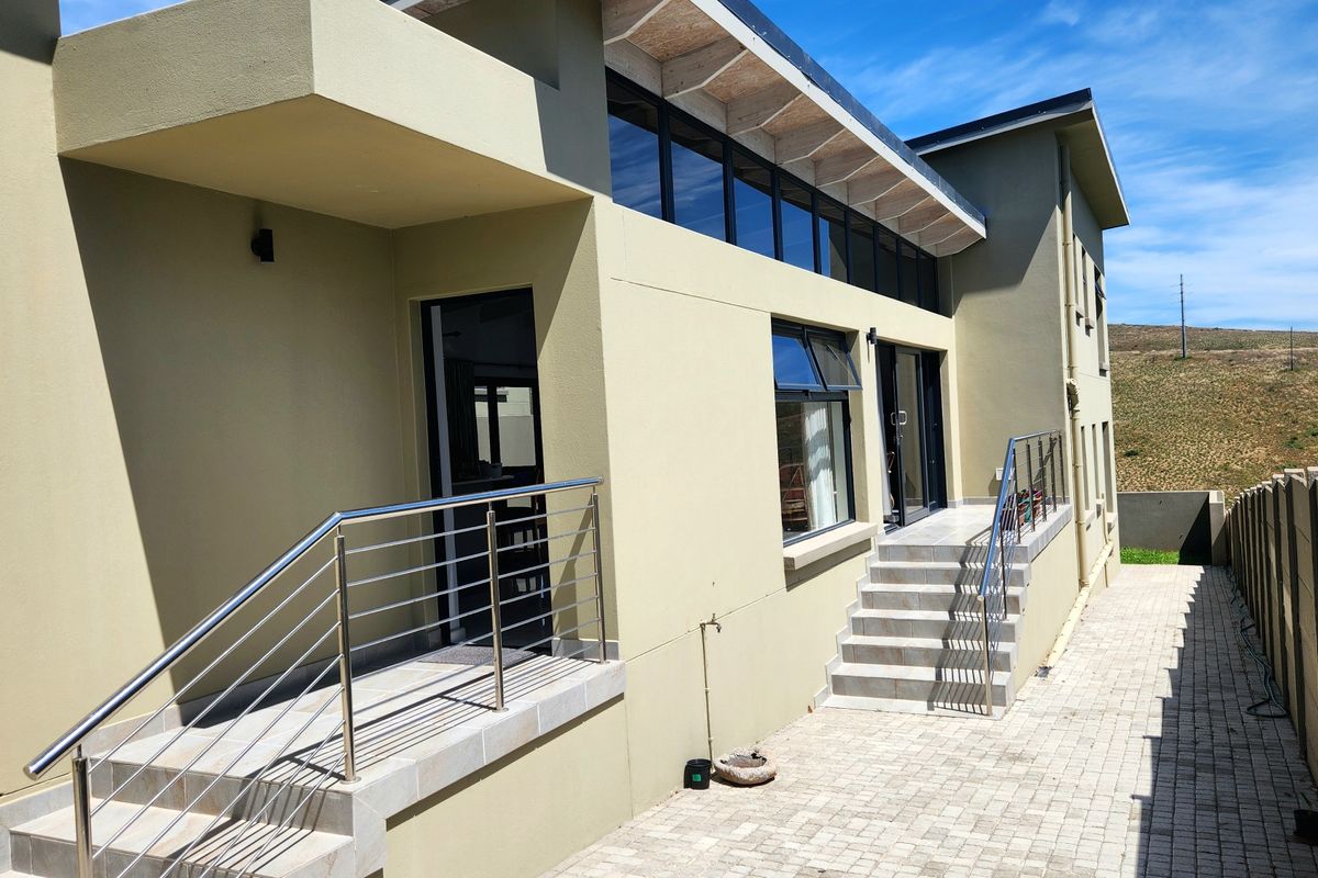 Rear exterior view of the duet property featuring a paved walkway, tiled stairs with stainless steel balustrades, and modern clerestory windows.