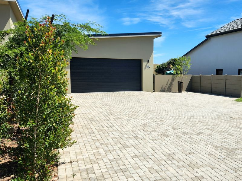 Front exterior view of the property featuring a paved driveway and a modern automated garage door.