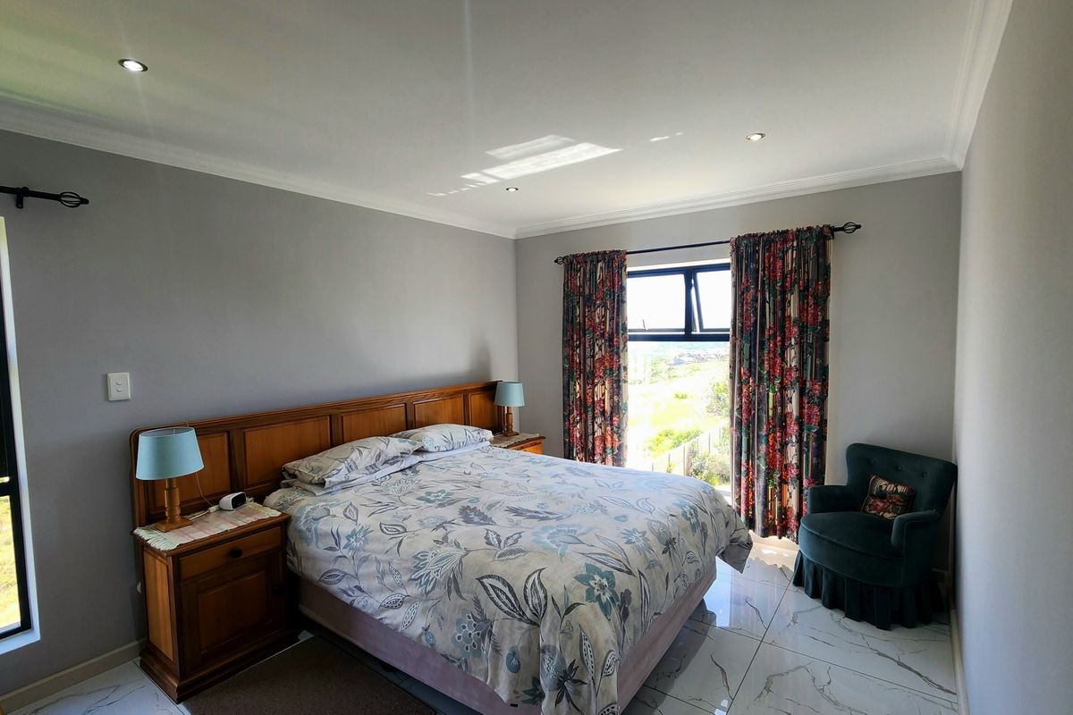 A well-maintained bedroom featuring tiled flooring, recessed downlighting, and large windows with natural light, offering a clean and comfortable living space.
