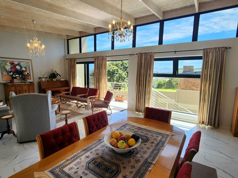 Spacious open-plan living and dining area featuring high exposed timber ceilings, large clerestory windows, and sliding doors leading to an outdoor balcony.