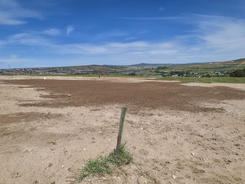 A vacant residential plot of land featuring clear road access and expansive landscape views, ready for development.