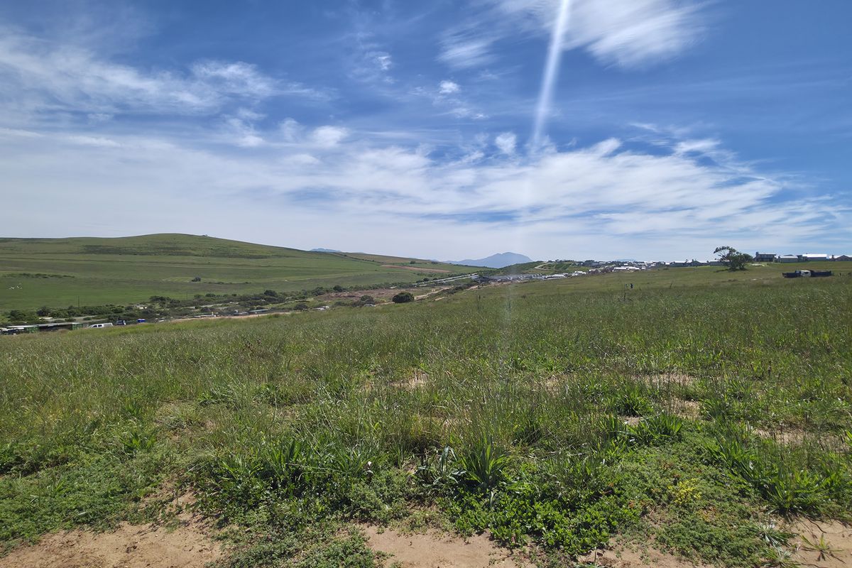 A wide-angle view of the vacant residential land, showcasing the surrounding landscape and natural terrain.