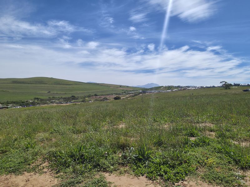 A wide-angle view of the vacant residential land, showcasing the surrounding landscape and natural terrain.