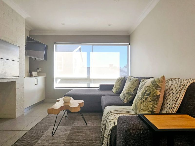 A well-maintained living room featuring a built-in fireplace, tiled flooring, and integrated cabinetry, offering a comfortable and functional living space.