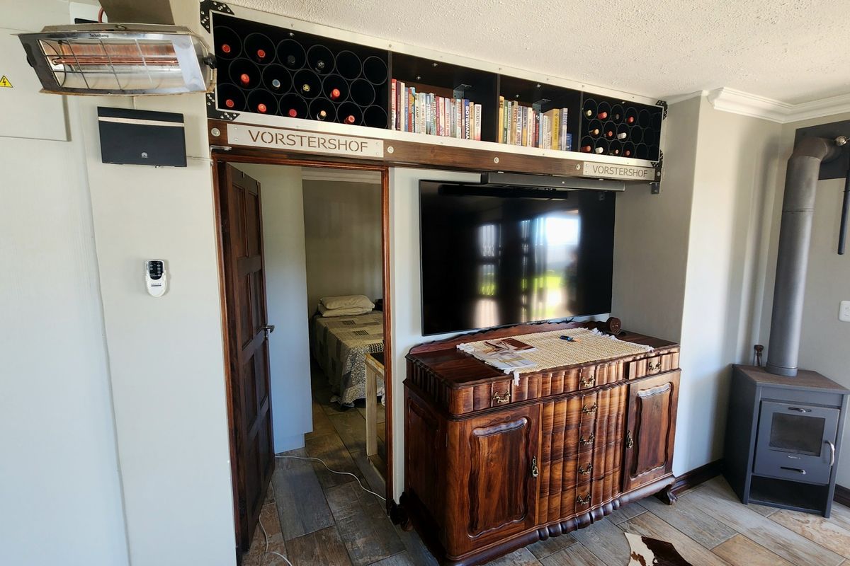 Living area featuring a built-in wine rack, wood-burning fireplace, and direct access to an adjacent bedroom.