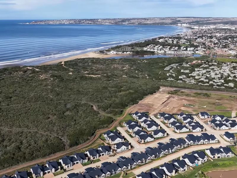 An aerial view of a coastal residential estate development, showcasing the proximity to the coastline and surrounding natural landscape.