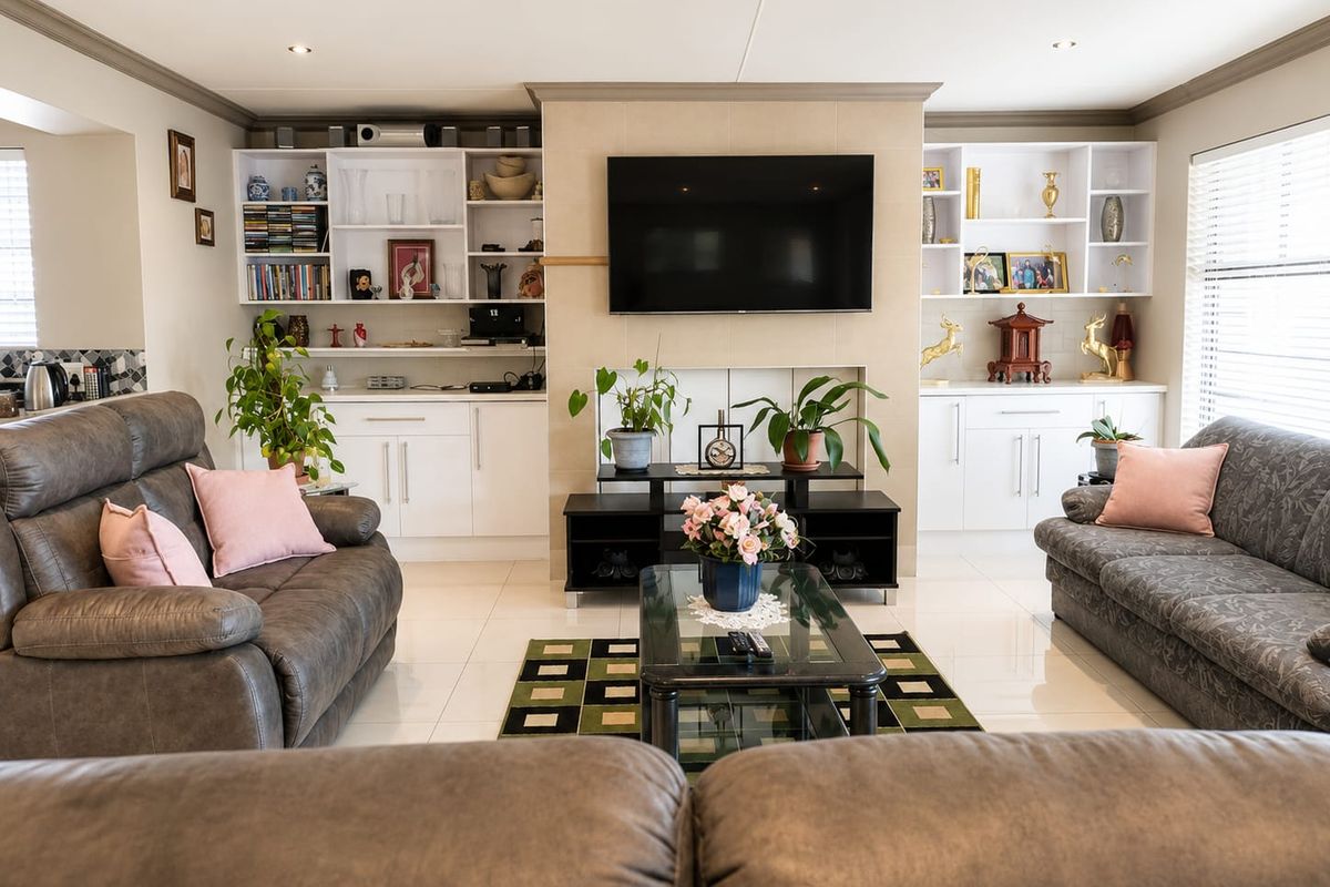 Spacious living room featuring built-in cabinetry, tiled flooring, and recessed lighting, creating a comfortable and well-maintained family space.