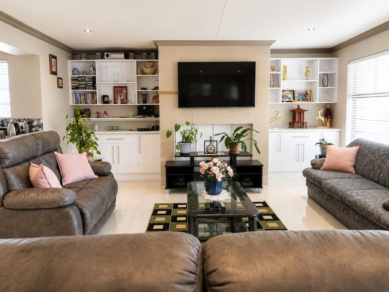 Spacious living room featuring built-in cabinetry, tiled flooring, and recessed lighting, creating a comfortable and well-maintained family space.