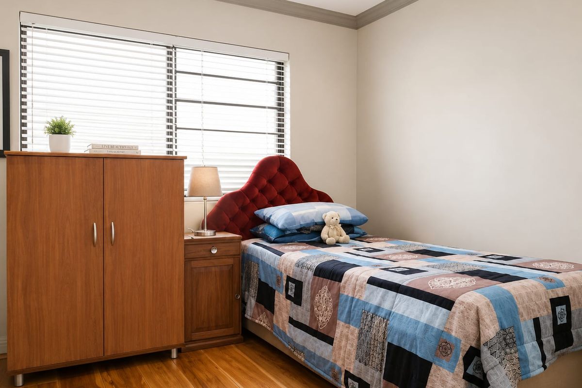 A well-maintained bedroom featuring timber flooring, recessed downlighting, and venetian blinds, offering a clean and neutral living space.