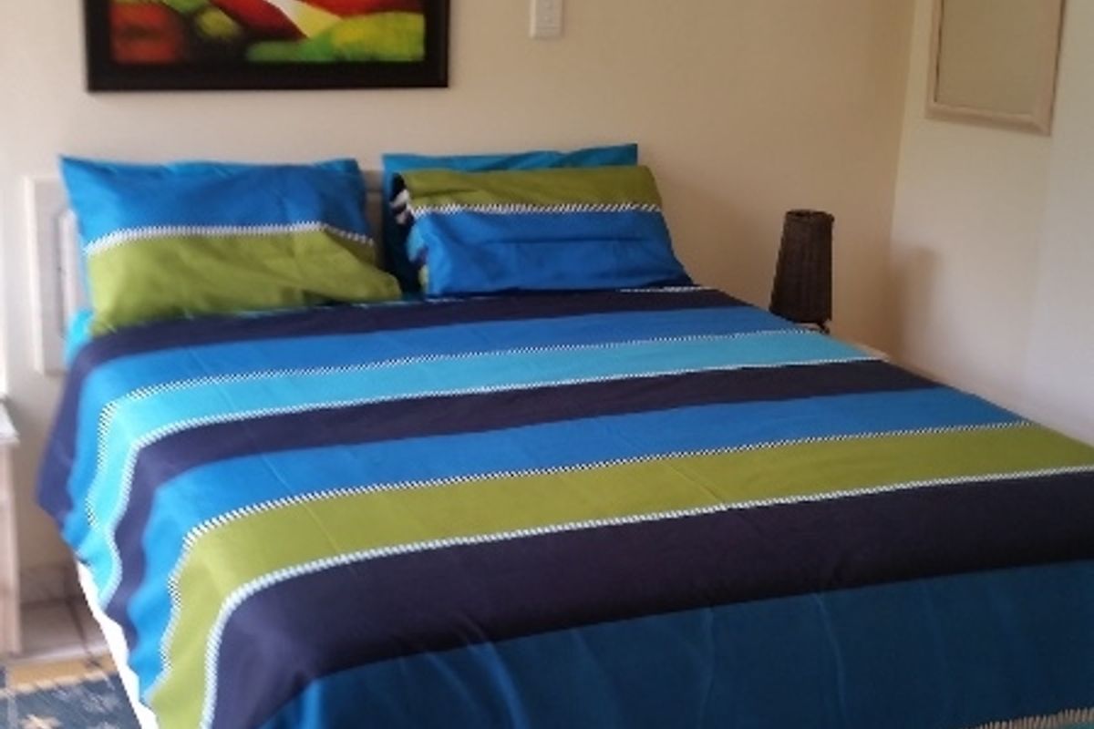 A bedroom featuring tiled flooring and a wall-mounted air conditioning unit.